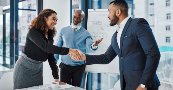 Shot of businesspeople shaking hands during a meeting in an office