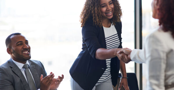 Cropped shot of two young businesswomen shaking hands during a meeting in the boardroom